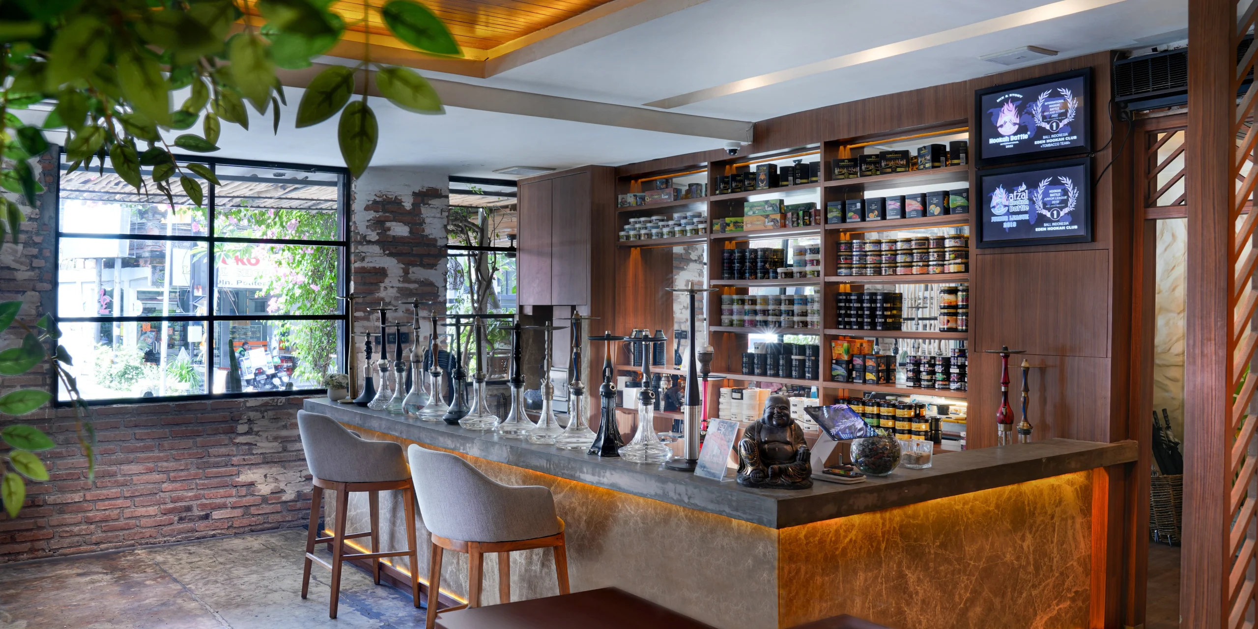 A cozy, modern hookah lounge displaying a variety of premium pipes on a concrete bar counter, setting the stage to find the best shisha device for your collection.