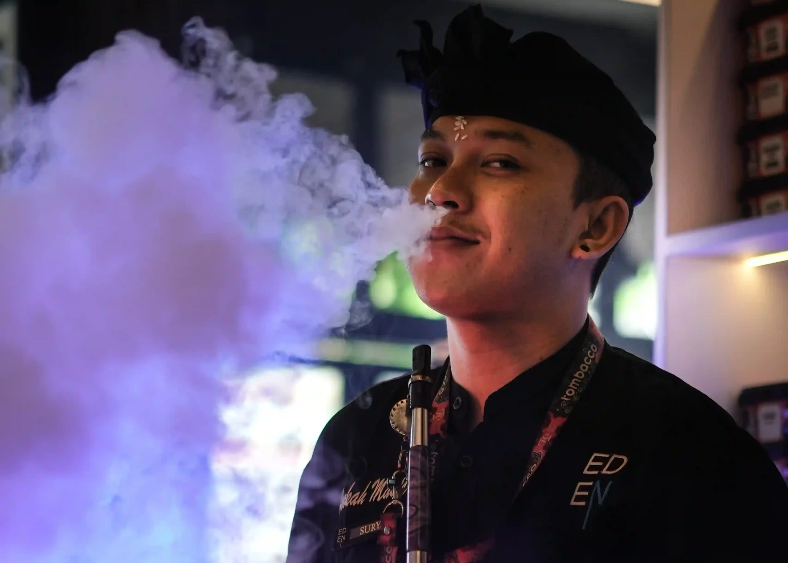 A friendly hookah expert blowing thick white clouds, always ready to share professional tips with you if you are first time trying hookah and need setup advice.