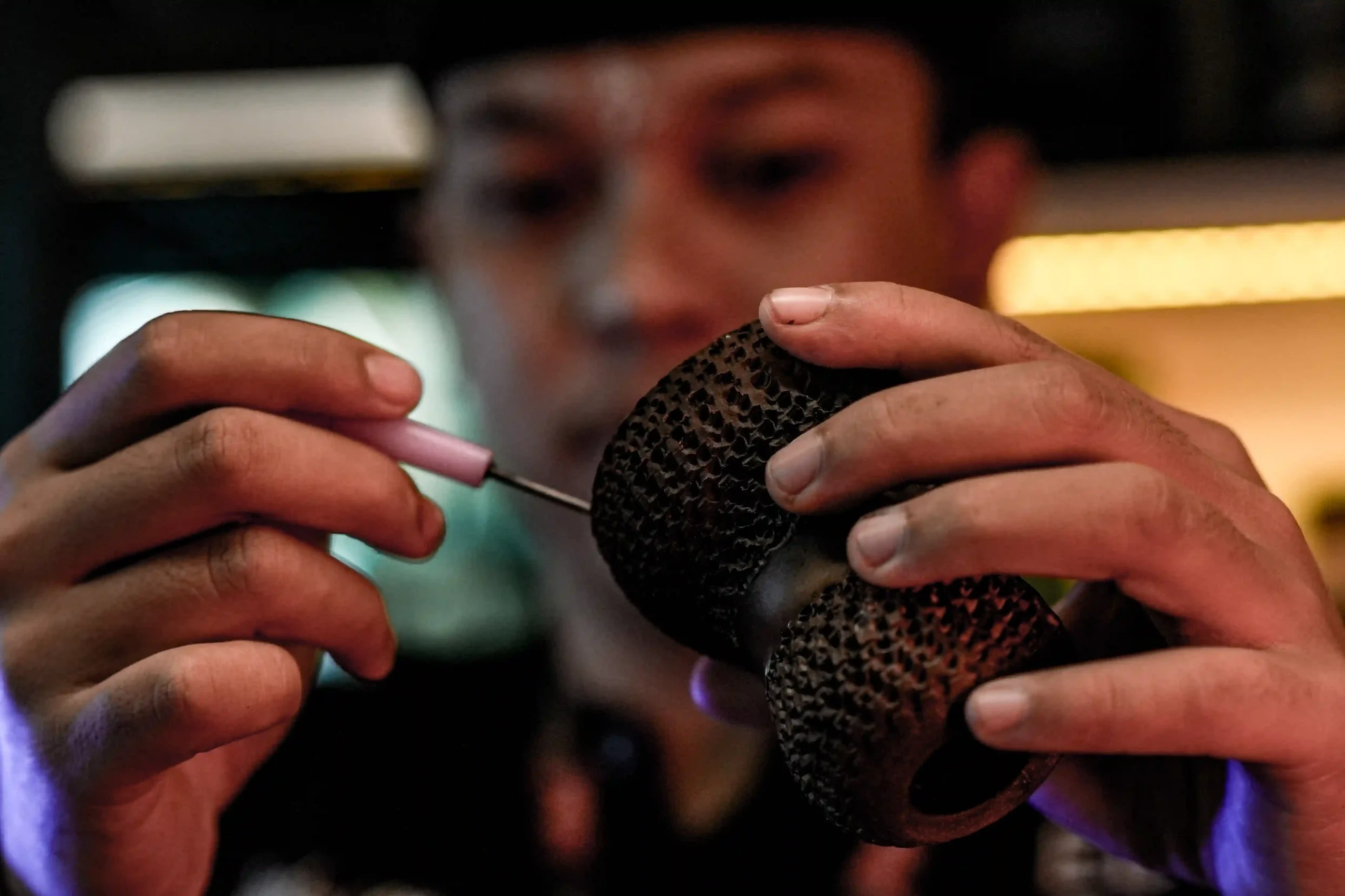 Close up of hands carefully packing blonde leaf tobacco into a phunnel bowl, which is an essential step to master when you are first time trying hookah to avoid a burnt taste.