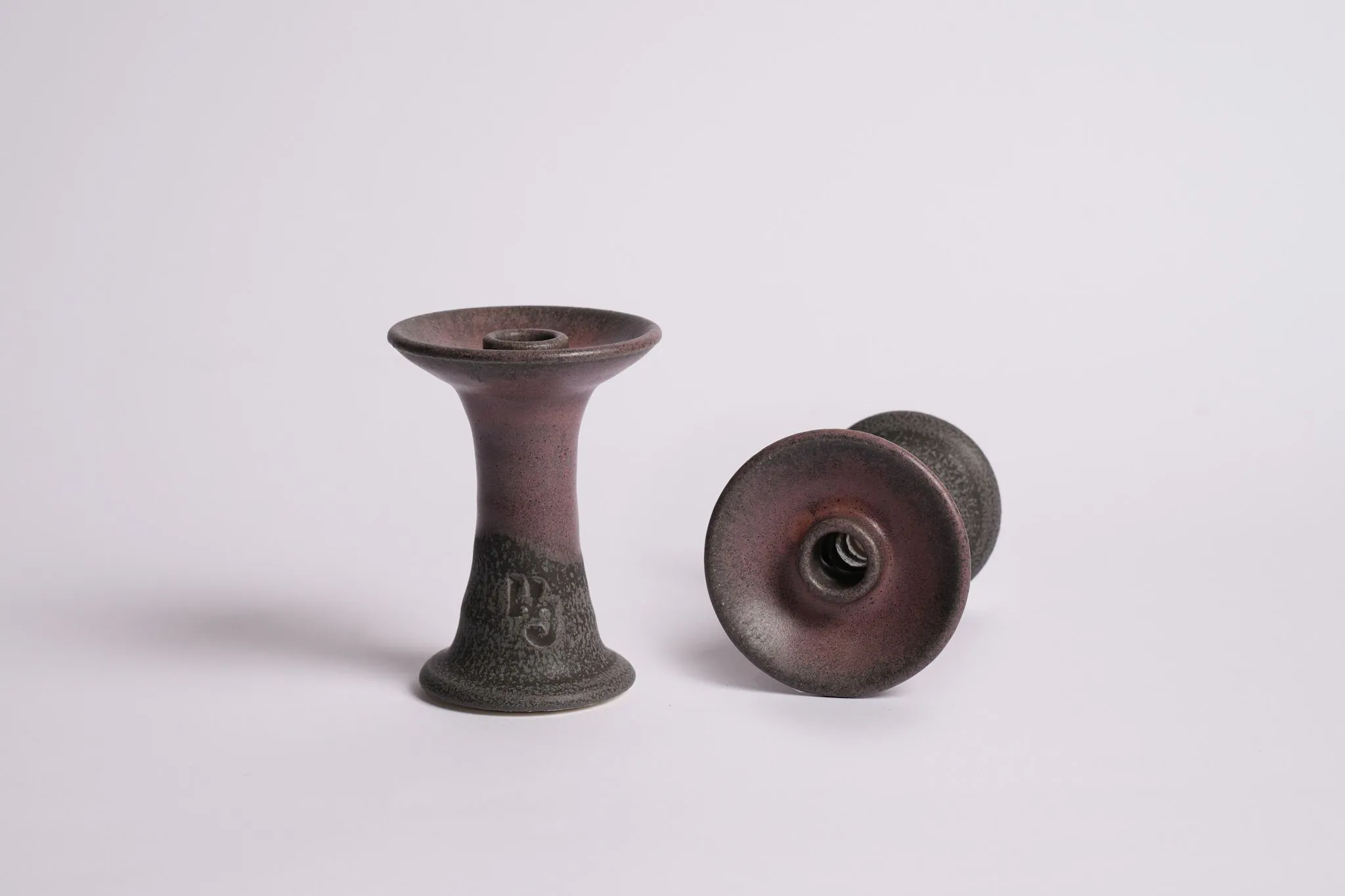 A close-up of a shallow Alien bowl featuring a beautiful maroon and black glaze. Among the various hookah bowl types, this specialist design is perfect for short, high-intensity sessions with dark leaf tobacco.